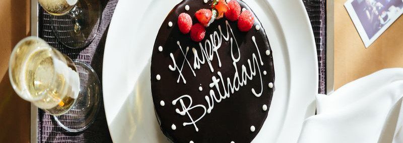A chocolate Happy Birthday Cake alongside a bottle of champagne. This is part of our Birth Celebration Package on our website.
