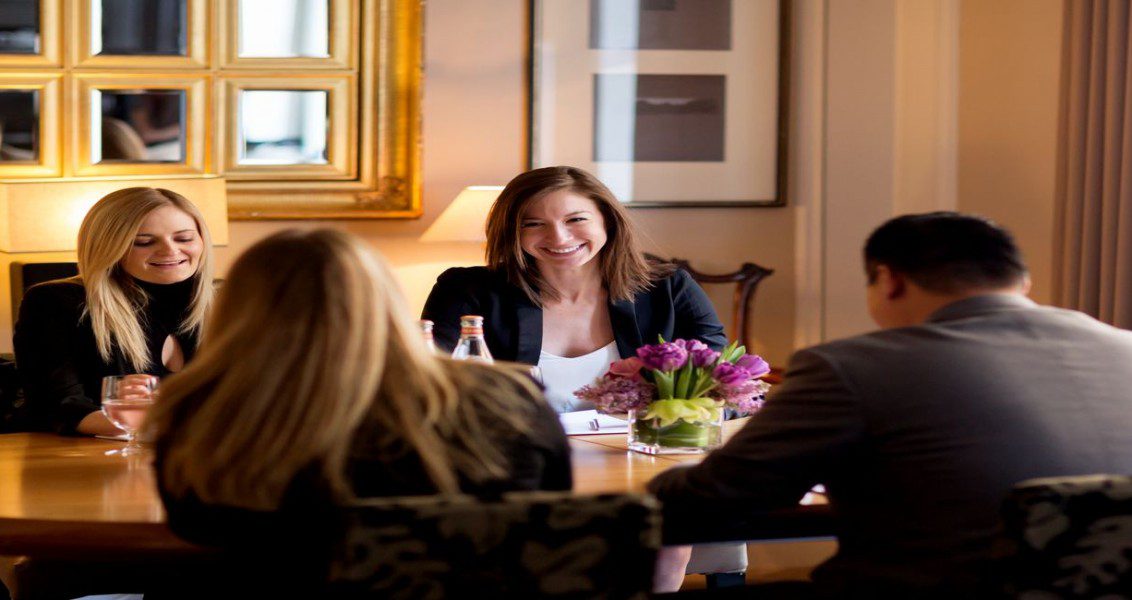 four people having a meeting in one of our parlor rooms.