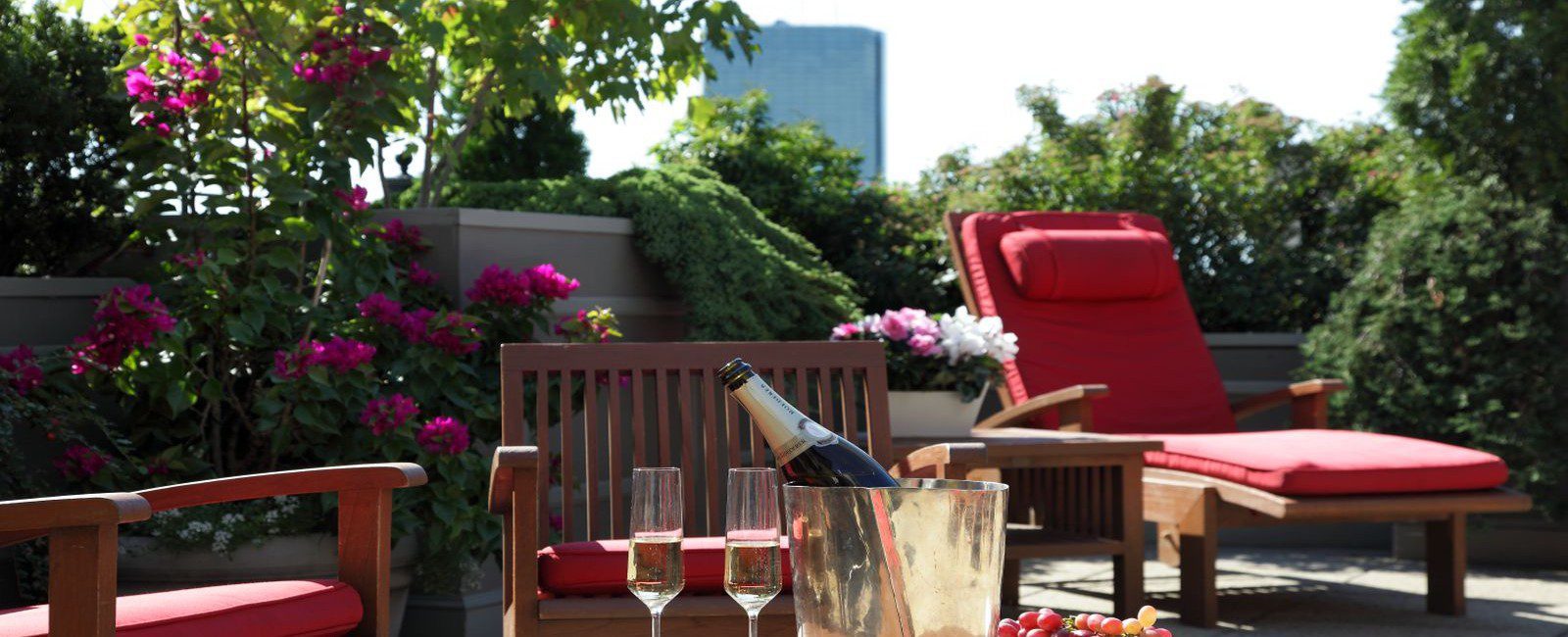 Photograph of our roof deck during the summer season. Bottle of champange and fresh grapes are showcased on the table as you are allowed to bring food and beverages up at your leisure