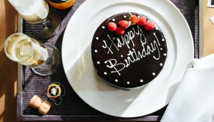 A chocolate Happy Birthday Cake alongside a bottle of champagne. This is part of our Birth Celebration Package on our website.