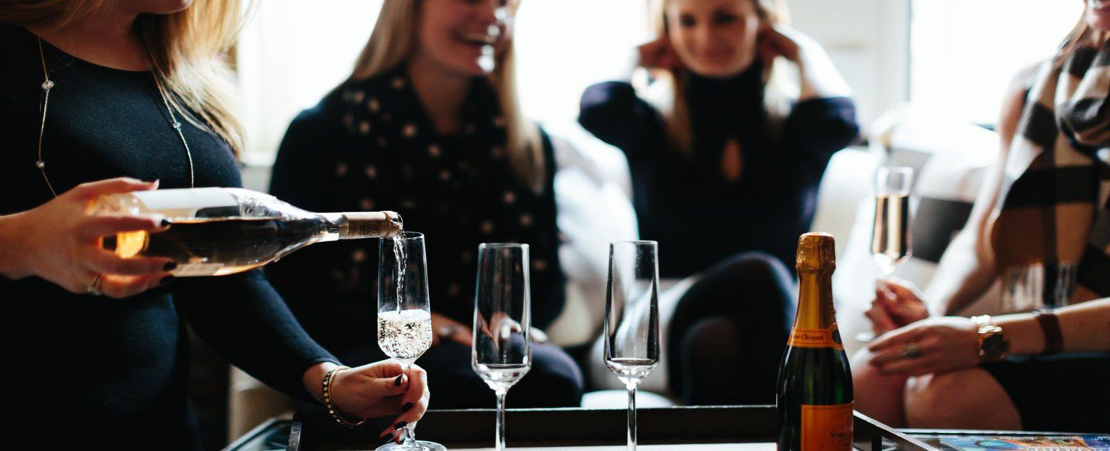 Four young lady celebrating with a champagne toast.
