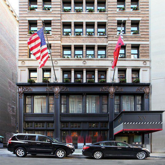 Exterior of Fifteen Beacon from the street along side our two black cars.