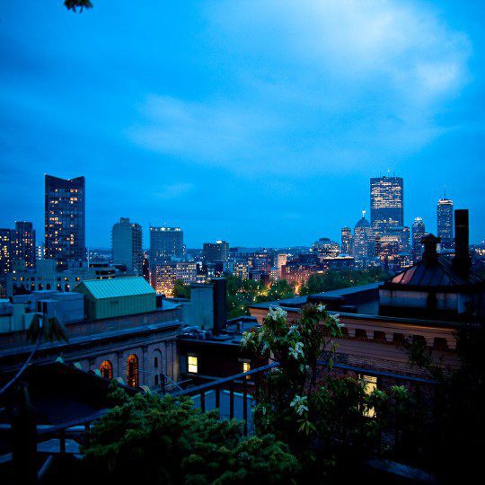 Fifteen Beacon's view from our roof deck overlooking Boston's building after dark.