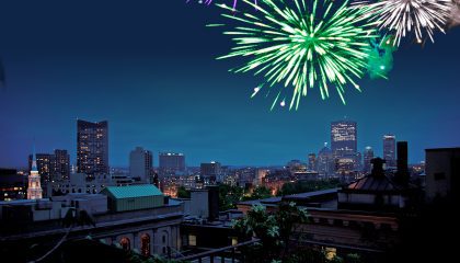 roof deck photo at night with green, gold, and silver fireworks