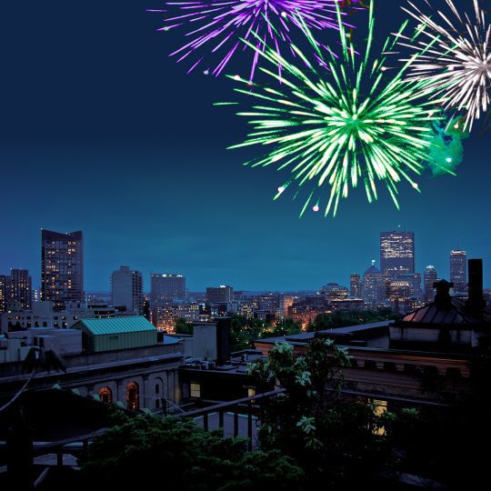 roof deck photo at night with green, gold, and silver fireworks