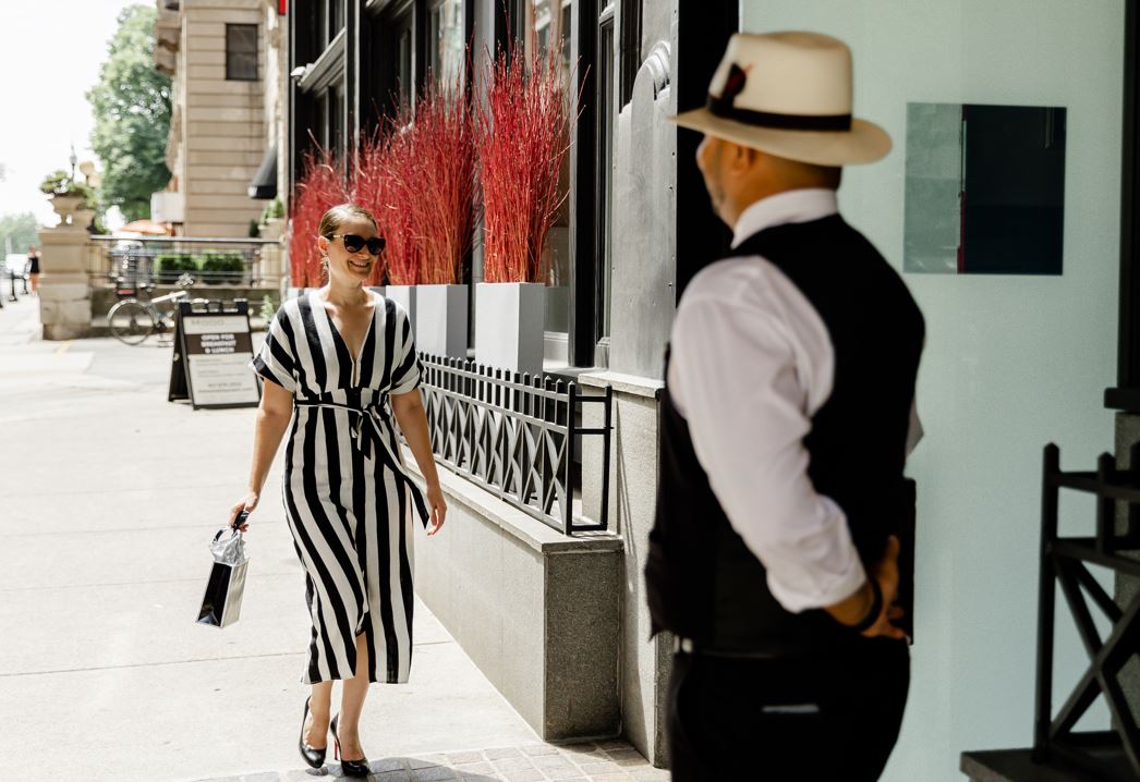 guest walking with a shopping bag on the sidewalk in front of XV Beacon hotel