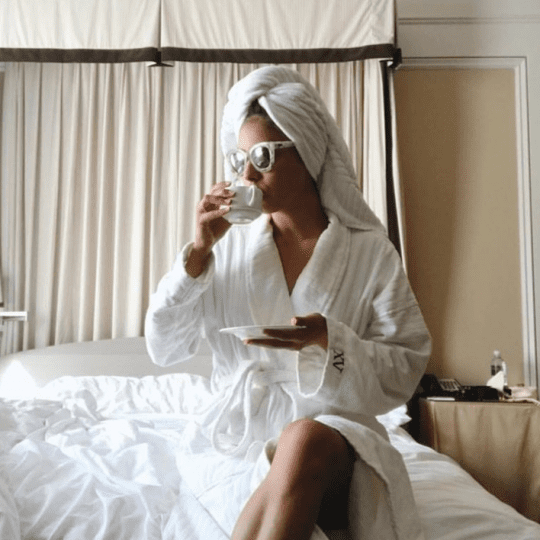 woman on XV Beacon Bed with our custom Frette Robes