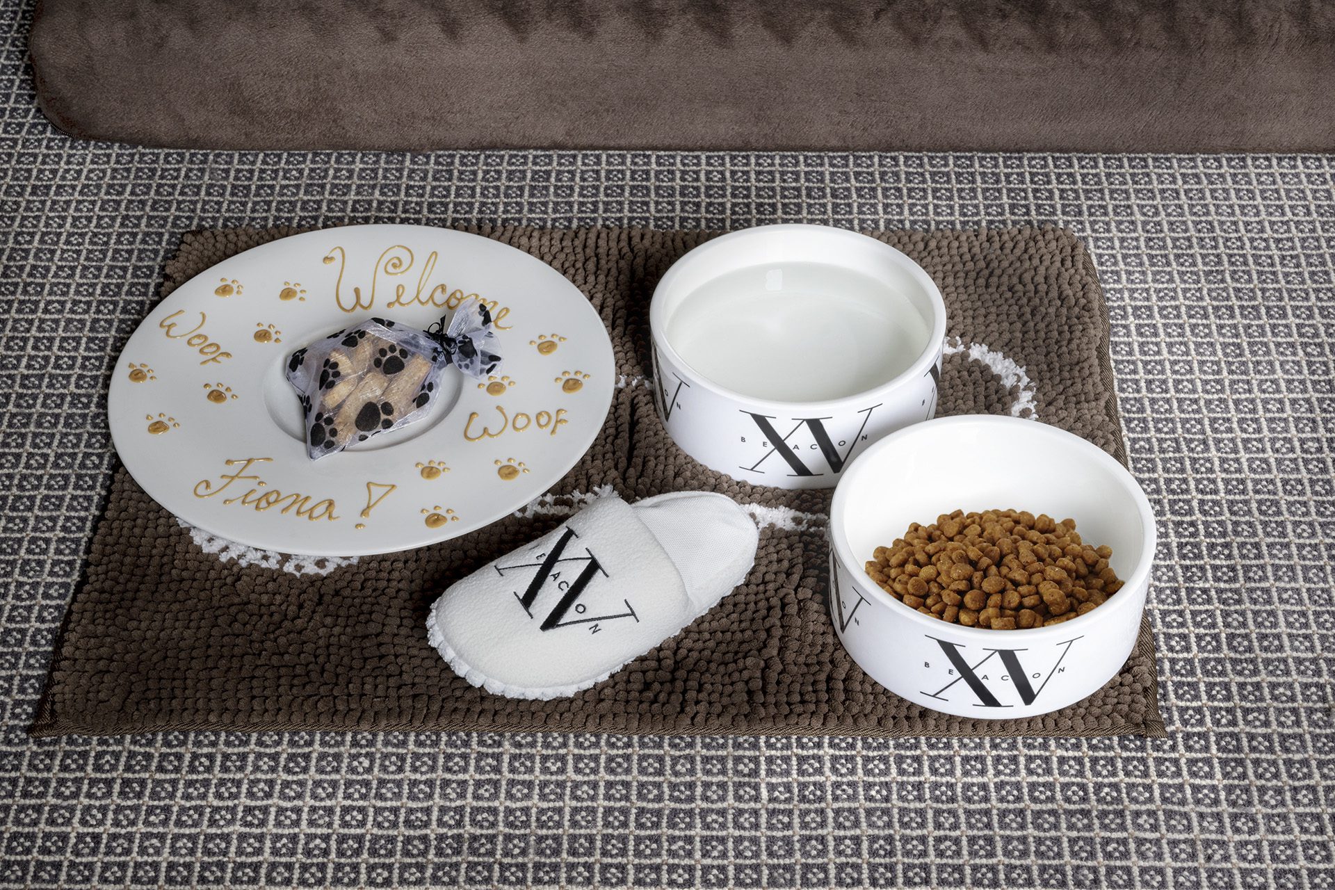 photo of our dog amenity with dog treats and a plush dog chew toy slipper